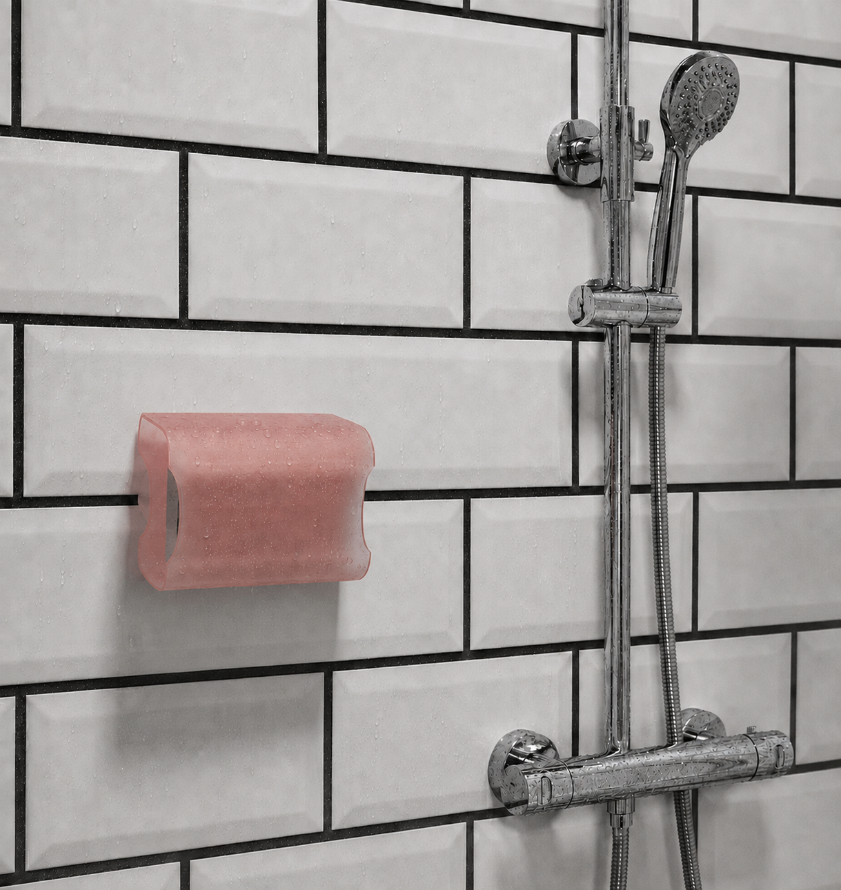 Jabonera O rosa translúcida instalada en una ducha blanca con juntas negras